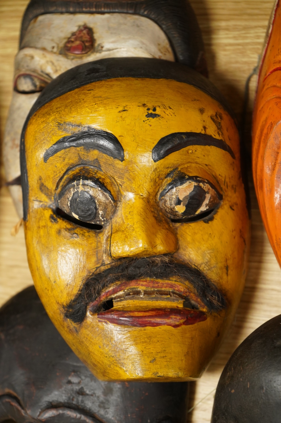 A collection of seven Nepalese, African and Indonesian masks to include a Magar example and one from the Dan Tribe, Liberia, largest 40cm